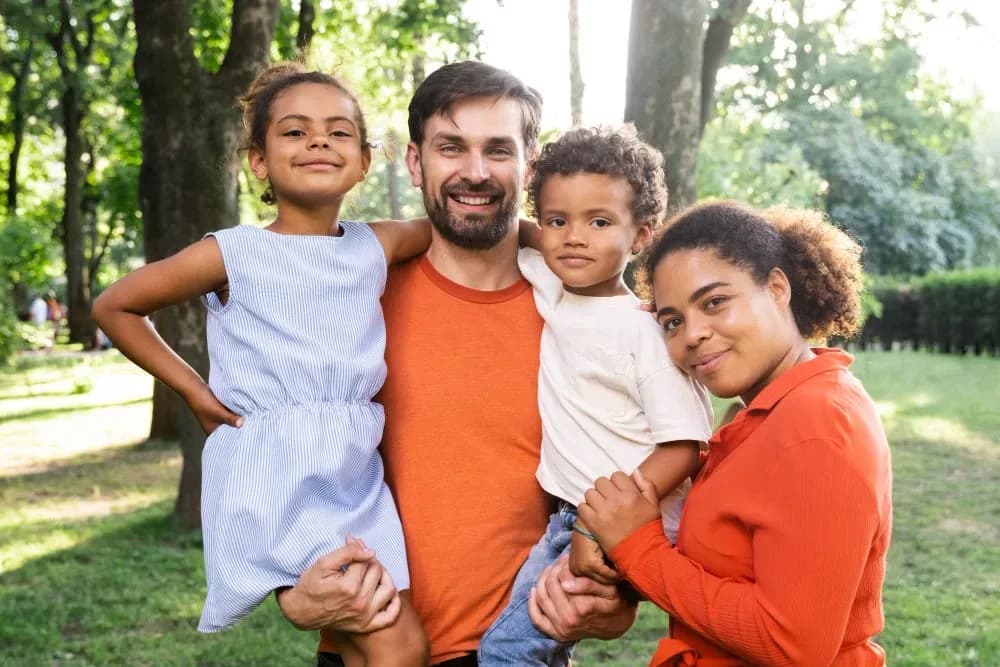 Happy family with a young child smiling outdoors - gentle pediatric dental care at Neola Dental in Minneola, FL